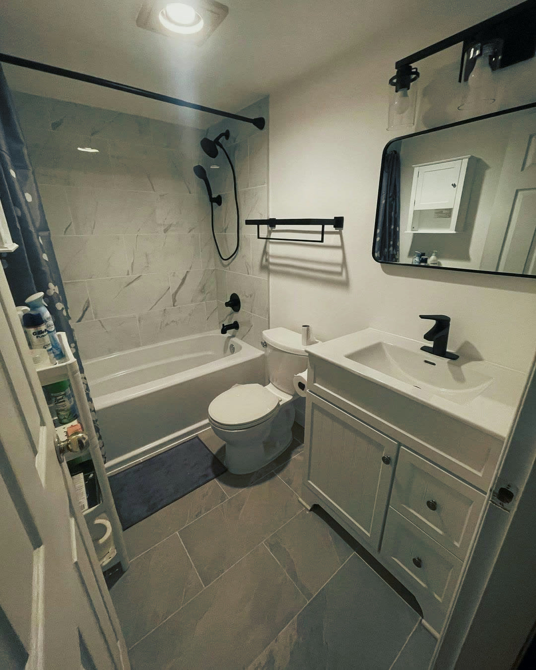 New vanity, black-framed mirror and black vanity light in the completed bathroom.