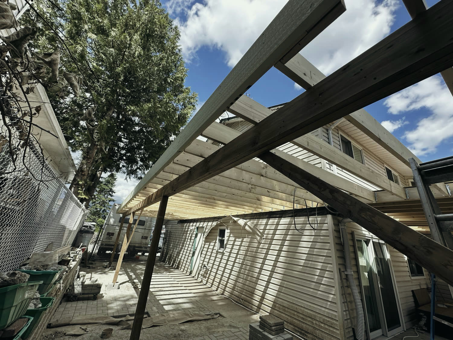 New timber framing for the deck roof going up over the lower patio.