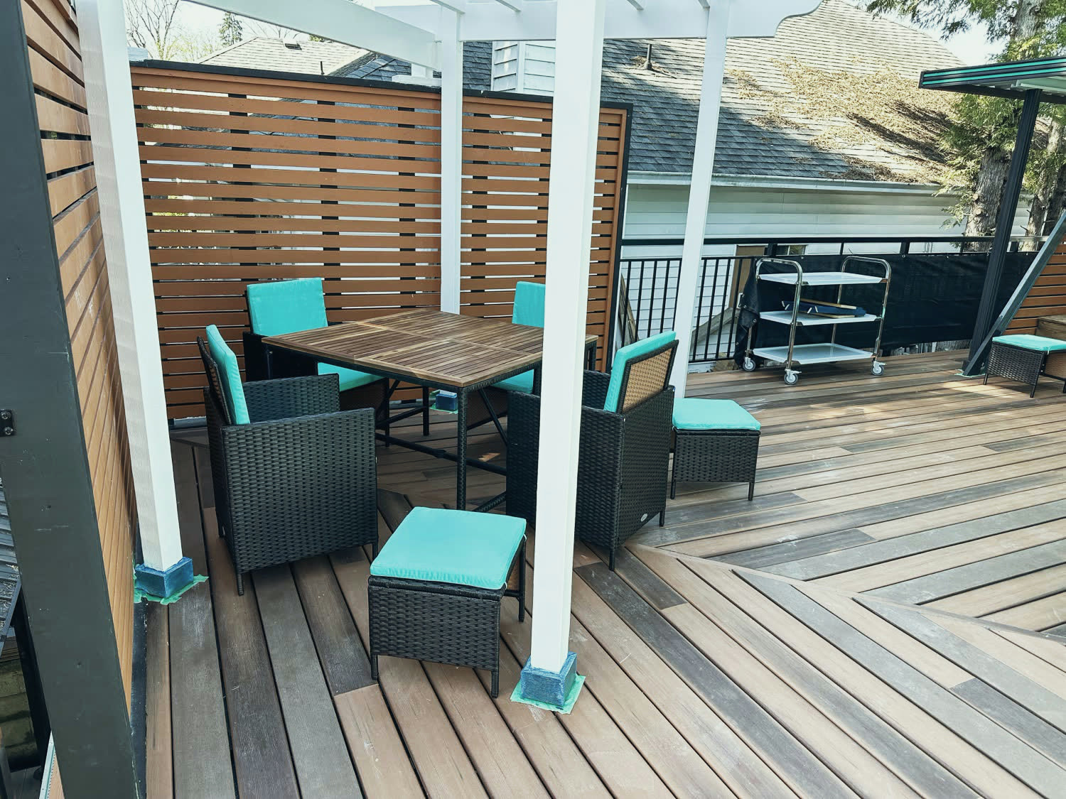 Dining area under the new white pergola, enclosed by slatted privacy screens.