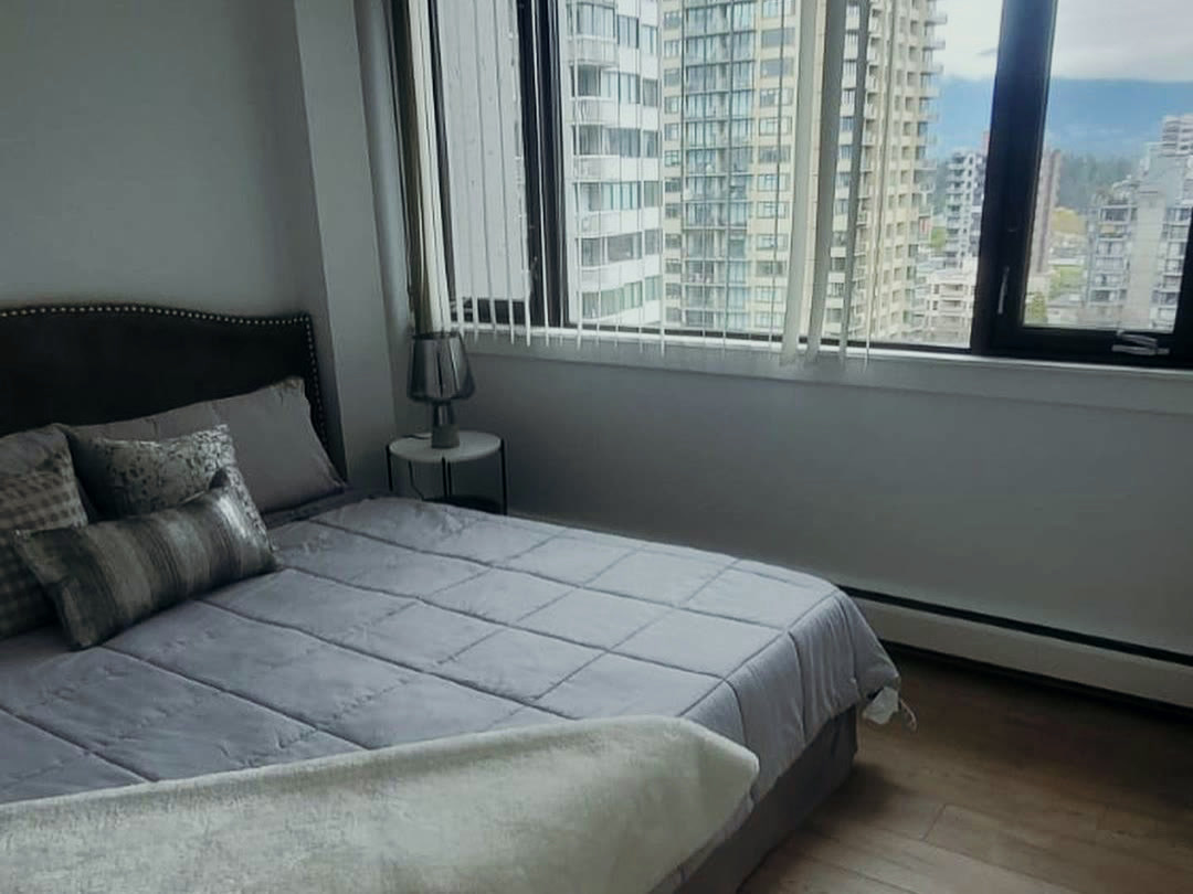 A completed bedroom with corner glazing looking out over the city.