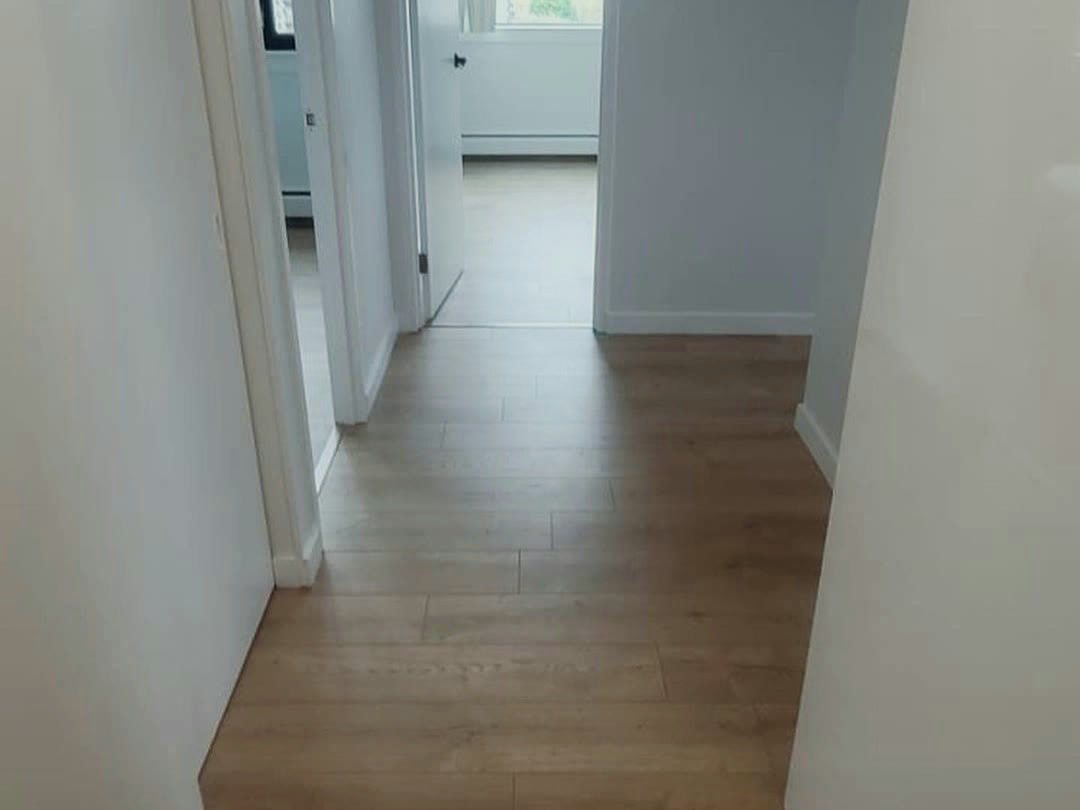 The hallway after completion, with new wood-look flooring running through to the bedrooms.